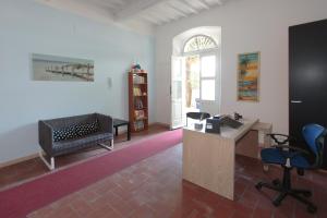 sala de estar con sofá, escritorio y sillas en Magnolia Comfort & Rooms, en Pisa