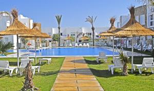 a resort with a swimming pool with chairs and umbrellas at Mnar Park aqua park in Tangier