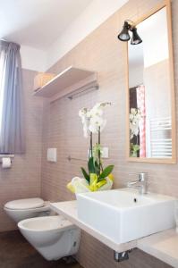 a bathroom with a sink and a toilet and a mirror at Milò casa vacanze in Cupra Marittima