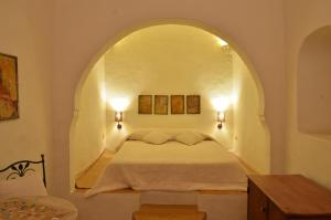 a bedroom with a white bed and white walls at Hotel Dar Dhiafa in Houmt Souk