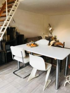 - une table à manger et des chaises blanches dans la chambre dans l'établissement Unieke stadswoning voor 2 personen met Finse sauna, à Apeldoorn