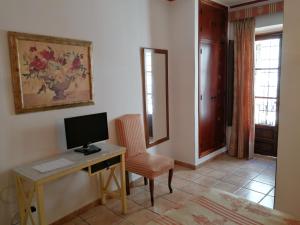 Habitación con escritorio, ordenador y silla. en Hostal Maestre, en Córdoba