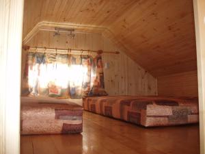 two beds in a room with a window at Chaty Dagmar in Liptovský Mikuláš
