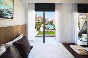 a bedroom with a bed with a view of a balcony at Elysia Park in Paphos