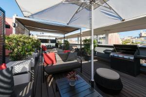 a balcony with an umbrella and a couch and chairs at Hotel Jazz in Barcelona