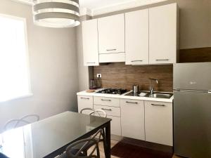 a kitchen with a stove, refrigerator, sink and dishwasher at Nettuno Suite in Syracuse