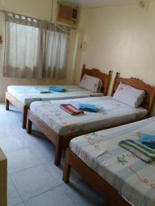 2 camas individuais num quarto com uma janela em Eco Pension em Surigao