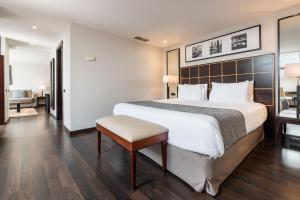 a hotel room with a large bed and a chair at Eurostars Ciudad de La Coruña in A Coruña