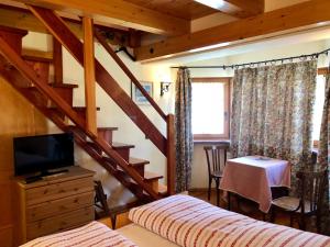 a bedroom with a staircase with a table and a television at Stella Alpina in Voltago