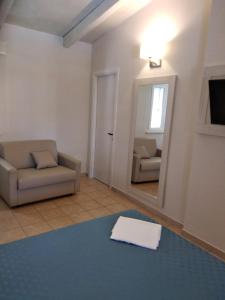 sala de estar con sofá y espejo en Villaggio Verde Cupra, en Cupra Marittima