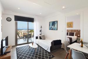 a bedroom with a bed and a living room with a view at Elysia Park in Paphos
