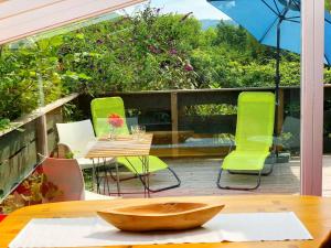 - une table et des chaises sur une terrasse avec un parasol dans l'établissement Vintage Chalet in Sougn Remouchamps near Forest, à Aywaille