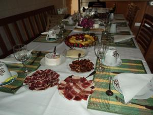 a table with a white table cloth with food on it at Casa Villar Mayor in Vilar Maior