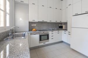 a white kitchen with a sink and a refrigerator at Traditional Town Home with Amazing View! in Mikonos