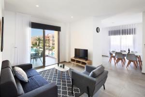 a living room with a couch and a tv and a table at Elysia Park in Paphos