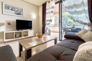 プエルト・デ・サンティアゴにある2BED Ocean Apartment in Los Gigantesのリビングルーム(ソファ、テーブル付)