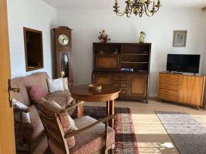 ein Wohnzimmer mit einem Sofa, einem Tisch und einem TV in der Unterkunft Ferienwohnung King in Triberg