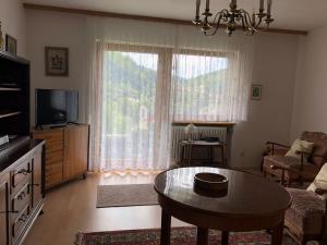 ein Wohnzimmer mit einem Tisch und einem großen Fenster in der Unterkunft Ferienwohnung King in Triberg