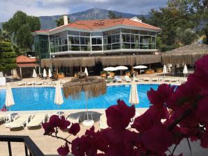 a resort with a swimming pool with chairs and umbrellas at Telmessos Select Hotel - Adult Only (+16) - All Inclusive in Oludeniz