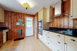 a kitchen with white cabinets and wooden walls at Necessary Escape in York