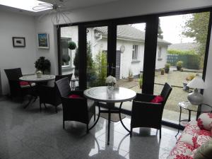a dining room with a table and chairs and windows at Pearse Lodge in Sligo