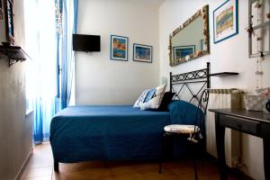 una camera da letto con un letto con una coperta blu e una scrivania di Affittacamere Rollando a Vernazza