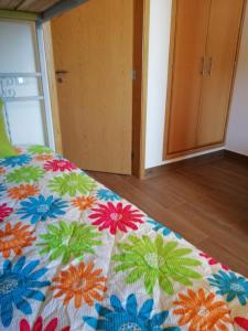 a bedroom with a bed with a colorful quilt on it at Sol Mar in Odeceixe