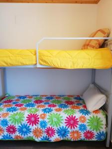 a bunk bed with a flower pattern on the bottom bunk at Sol Mar in Odeceixe