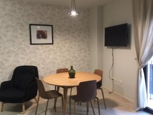 a dining room with a table and chairs and a television at Puerta Trujillo in Plasencia