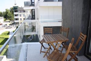 d'une table en bois et de deux chaises sur un balcon. dans l'établissement Nadmorska Bryza Sopot Integro, à Sopot