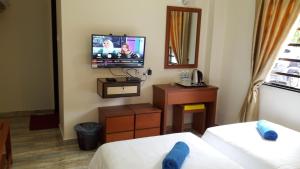 a hotel room with two beds and a flat screen tv at TULIP HOTEL & APARTMENT in Cameron Highlands