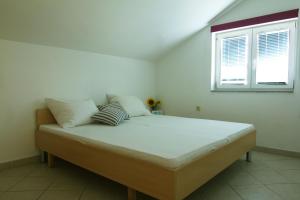 ein großes Bett in einem Zimmer mit Fenster in der Unterkunft Apartments Nebeska in Novalja