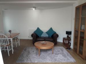 een woonkamer met een bank en een tafel bij The Cottage in Redruth