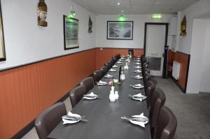 a long dining room with a long table and chairs at The Gurkha Hotel in Blackpool