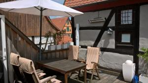 una mesa y sillas con una sombrilla en el patio en Altstadthaus Dinkelsbühl, en Dinkelsbühl