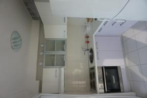 - une cuisine blanche avec évier et four micro-ondes dans l'établissement Apartments Silvija, à Pisak