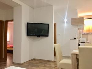 a living room with a television on a wall at Apartman AS in Bihać