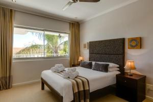 a bedroom with a bed with two towels on it at 42 On Strathmore in Cape Town +37 photos