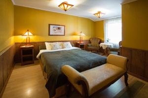 a bedroom with a bed and a chair and lamps at Villa Eeden in Pärnu