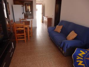 ein Wohnzimmer mit einem blauen Sofa und einem Tisch in der Unterkunft Las Cañas Luisa in Tarifa
