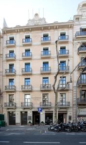 un gran edificio con motos estacionadas frente a él en Hotel Constanza en Barcelona