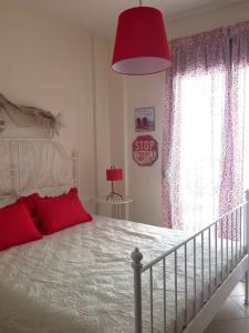 1 dormitorio con cama blanca y lámpara roja en La casa allegra in rosso en Siviri