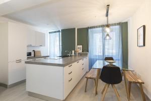 cocina con encimera, mesa y sillas en Honeymoon Apartment by Quokka 360 - romance by the lake, en Morcote