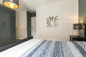 モルコテにあるHoneymoon Apartment by Quokka 360 - romance by the lakeのベッドルーム1室(ベッド1台付)が備わります。壁には絵画が飾られています。