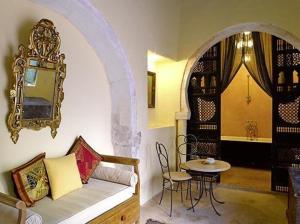 ein Wohnzimmer mit einem Sofa und einem Tisch in der Unterkunft Hotel Dar Dhiafa in Houmt Souk