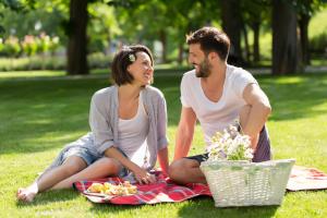 Ein Mann und eine Frau sitzen auf einer Decke im Gras in der Unterkunft Hotel Zagreb - Health & Beauty in Rogaška Slatina
