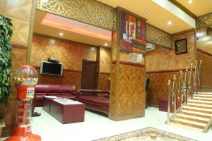 a lobby with a couch and a tv and stairs at Emirates Plaza Hotel in Ajman 