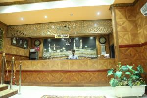 a man standing behind a bar in a restaurant at Emirates Plaza Hotel in Ajman 