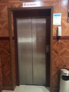 a metal elevator in a building with a no smoking sign at Emirates Plaza Hotel in Ajman  +2 photos