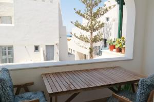 a table and chairs on a balcony with a view of the ocean at Wave Home Naxos Town in Naxos Chora